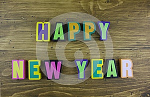 The colorful word `Happy New Year` over the wooden board.
