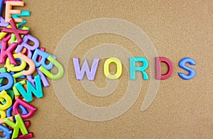 The colorful word `Words` over the wooden board.