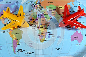 Colorful world map with airplane on it with the continents Africa, Europe, North America, Asia, South America, Australia and