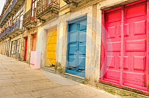 Colorful worn painted doors along street in Porto