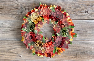 Colorful Wreath made of wooden flowers and leaves on vintage woo