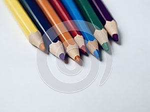Colorful writing implements lined up on white surface