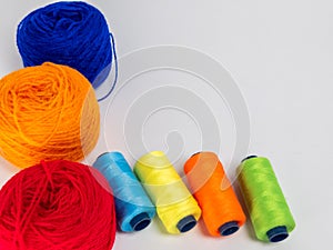 Colorful Yarn Balls and Thread Spools Arranged on a White Background