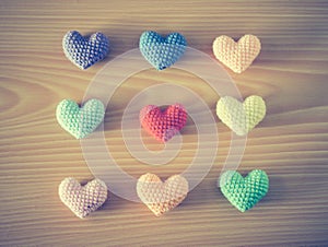 Colorful Yarn hearts on wood background