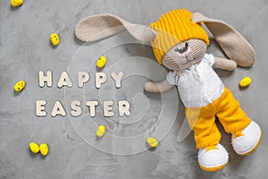 Colorful yellow Easter eggs, bunny toy and text happy easter