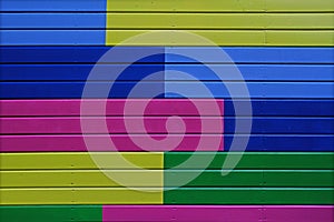 Colorful yellow, green, blue and pink painted wooden wall