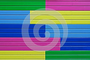 Colorful yellow, green, blue and pink painted wooden wall