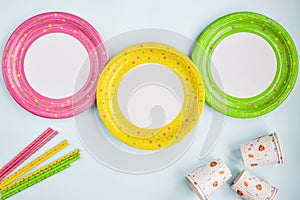 Colorful yellow, green, pink paper plates, Cup, straw.