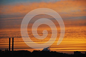 Colorful yellow orange dark dramatic evening sky over industrial