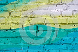 Colorful yellow and turquoise painted brick wall