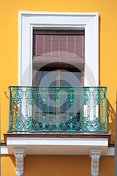 Colorful yellow window and turquoise balcony in Spain