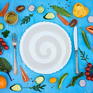 Colorfull fresh salad ingredients around empty white plate with