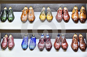 Colorfull pairs of shoes are exposed for sale.