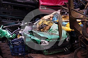 Colors on the junkyard, crushed turquoise scrap car, yellow garb