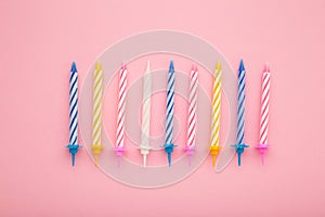 Coloruful birthday candles on pink background. Birthday celebration. Vertical photo