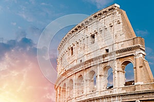 Colosseum or Coliseum ancient ruins background blue sky Rome, Italy, view from below, stone arches and sunrays