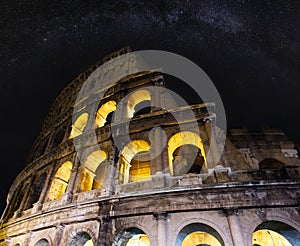 Colosseum ruins night view with Milky Way stars sky. The symbol of Imperial Rome, Italy