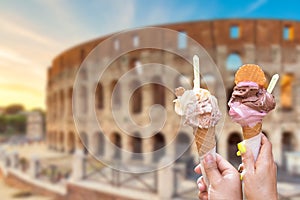 Colosseum at sunset in Rome, Italy with italian ice cream gelato in hands. World famous landmark in Italy