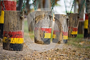 Colouful wooden swings in row. Outdoor children playground