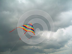 Colour bright flying kite against the storm sky