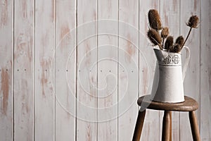 Colour Card and Vase on a Stool Over Blue Backdrop