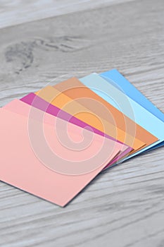 Colour paint swatch cards on a grey wood background