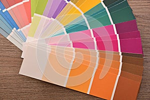 Colour palette in fan on wooden table close up top photo