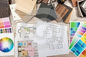 Colour palettes with house plan on desk top view. Designer working at new project