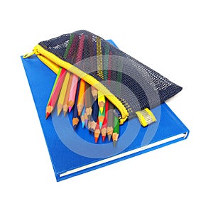 Colour pencils and a blue note book isolated on white background