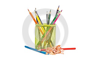 Colour pencils in pencil holder with color shavings on white