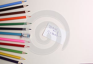 Colour pencils with sharpener lying on pastel beige background. Back to school concept sign written. Colorful art studying and