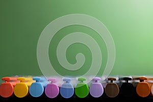 Colour pens lined up isolated on green background