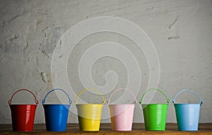Coloured buckets in line on the floor