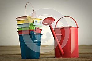 Coloured buckets and watering can on the floor