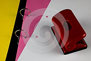 Coloured Card with Hole Punch and White Paper Sheet in an Open Ring Binder