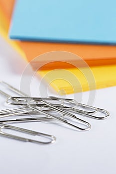 Coloured cardboard with paperclips on a white table
