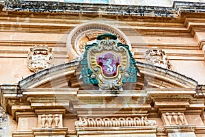 Coloured coat of arms of the archbishop above main entrance to the St Paul`s Cathedral in Mdina
