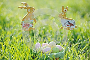 Coloured Easter eggs in a basket with rabbit decorations