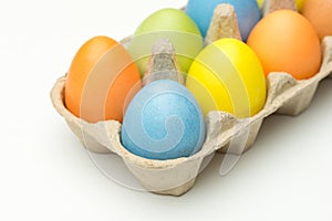 Coloured easter eggs in the box on wooden background