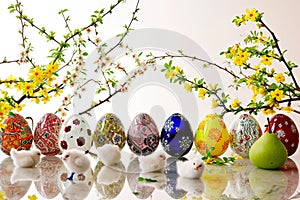 Coloured Easter eggs stand in an even row against a white background.
