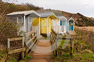 Coloured huts above a beach with boadwalk for access photo