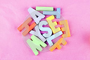 Coloured letters on a pink background