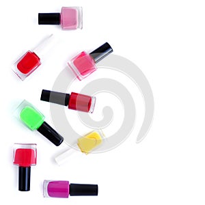 Coloured nail polish bottles on white background with copy space. Top view