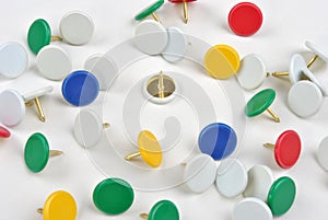 coloured office pins and a white background