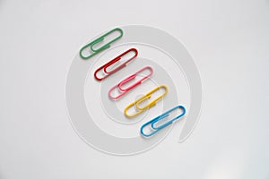 Coloured paper clips on a white background