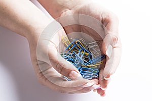 Coloured paperclips in a female hand