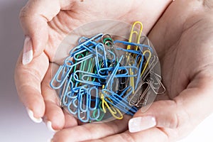 Coloured paperclips in a female hand