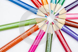 Coloured pencils arranged in a radial shape with the tips pointing towards the centre, back to school concept