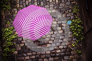 Coloured umbrella on alleyway