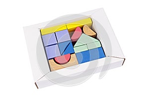 Coloured wooden figures in box on white background. Childrens building blocks. Geometric shapes. The concept of logical thinking